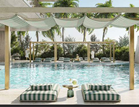 Luxury outdoor swimming pool area with striped lounge chairs, shaded canopies, and tropical landscaping.