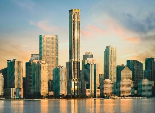 Skyline of a city with various modern high-rise buildings reflected on the water at sunset.